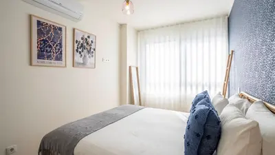 a bedroom with a bed and a blue wall at TrindadeFlat w AC by LovelyStay in Porto
