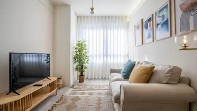 a living room with a couch and a tv at TrindadeFlat w AC by LovelyStay in Porto
