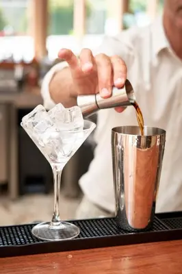 a man pouring a drink into a martini glass at The Log Porto Hotel by Piamonte Hotels in Porto