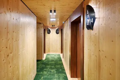 a hallway with wooden walls and a green carpet at The Log Porto Hotel by Piamonte Hotels in Porto