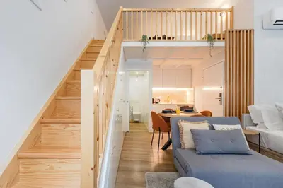 a bedroom with a bed and a stair case at 252 Heroísmo Duplex Flat in Porto