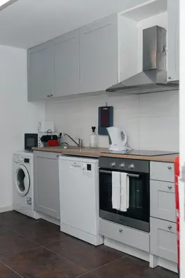 a kitchen with white cabinets and a washer and dryer at Ark of Aqua Flat in Porto