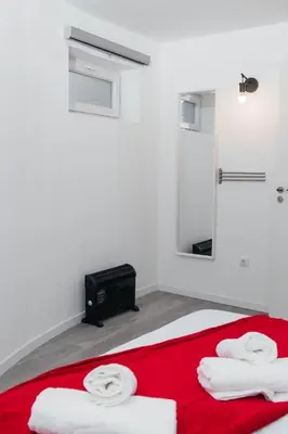 a bathroom with a bed with a red blanket and a mirror at Ark of Aqua Flat in Porto