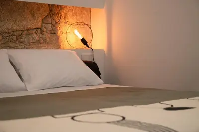 a bed with a white pillow and a lamp at St Ildefonso 02 in Porto