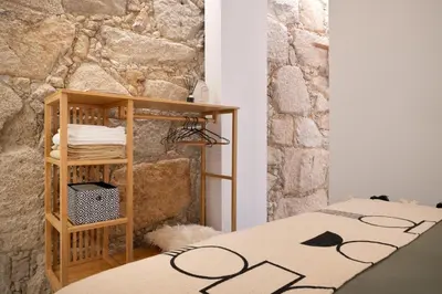 a room with a table and a stone wall at St Ildefonso 02 in Porto