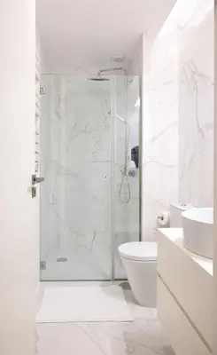 a white bathroom with a shower and a toilet at St Ildefonso 02 in Porto