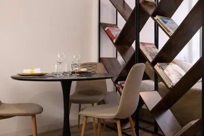a dining room with a table and chairs and a staircase at St Ildefonso 03 in Porto