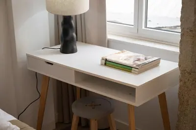 a table with a lamp and books on it next to a window at St Ildefonso 03 in Porto