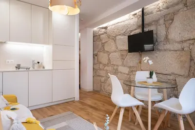 a living room with a table and white chairs at St Ildefonso 04 in Porto