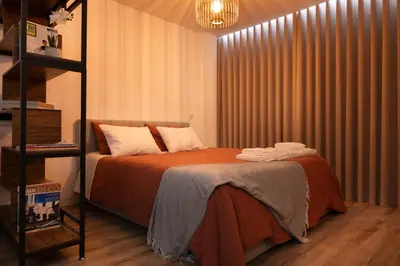 a bedroom with a bed with orange sheets and white pillows at St Ildefonso 05 in Porto