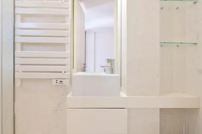 a white bathroom with a sink and a mirror at St Ildefonso 05 in Porto