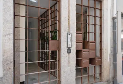 an open door with metal bars on a building at St Ildefonso 05 in Porto