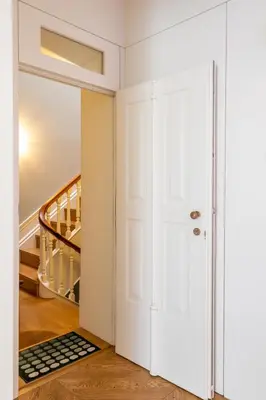 a hallway with a white door and a rug at Casa Flores - in Historical Center in Porto