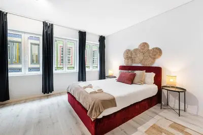 a bedroom with a large bed and some windows at GuestReady - Homely stay in Porto in Porto