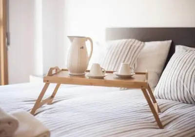 a wooden tray with a pitcher on top of a bed at Trindade 99 - Porto Downtown Apartment in Porto