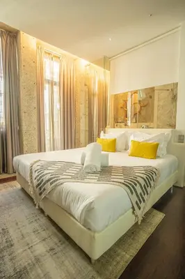a bedroom with a large white bed with yellow pillows at CHARM by YoursPorto in Vila Nova de Gaia