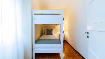 a bunk bed in a small room with a white bunk bed at 2BR Home near Douro River by LovelyStay in Vila Nova de Gaia