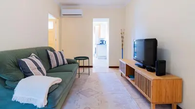 a living room with a green couch and a tv at 2BR Home near Douro River by LovelyStay in Vila Nova de Gaia