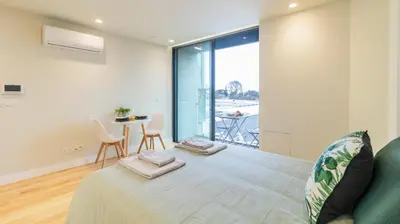a bedroom with a bed and a table with chairs at 3T Charming apartment in Boavista in Porto