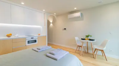 a bedroom with a bed and a table with chairs at 3T Charming apartment in Boavista in Porto