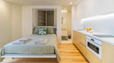 a small bedroom with a bed and a kitchen at 3T Charming apartment in Boavista in Porto