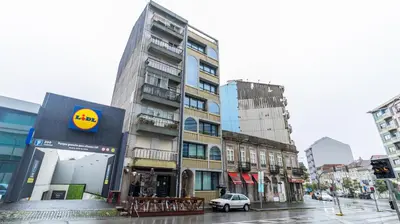 a building on a city street with a car at 3T Charming apartment in Boavista in Porto