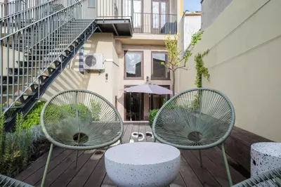 two chairs and a table on a wooden deck at Classy Garden in Porto