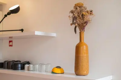 a vase with flowers in it sitting on a shelf at Classy Garden in Porto