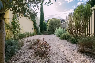 a garden with a gravel pathway with bushes and trees at Classy Garden in Porto