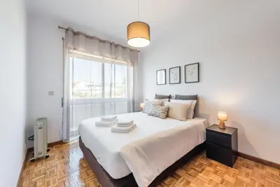 a bedroom with a large white bed with a window at GuestReady - Porto Panoramic View in Vila Nova de Gaia
