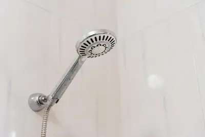 a shower with a shower head attached to a wall at GuestReady - Porto Panoramic View in Vila Nova de Gaia