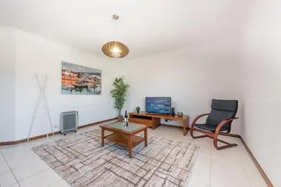a living room with a chair and a television at GuestReady - Porto Panoramic View in Vila Nova de Gaia