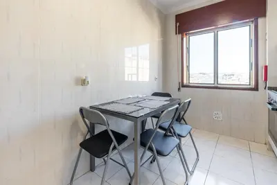 a table with four chairs in a room with a window at GuestReady - Porto Panoramic View in Vila Nova de Gaia