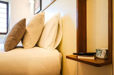 a bed with two pillows on it next to a table at Casa Priorado - Charming View City Center in Porto