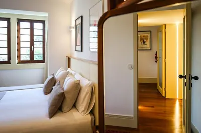 a bedroom with a bed with white sheets and pillows at Casa Priorado - Charming View City Center in Porto