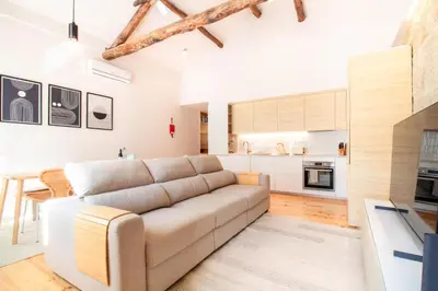 a living room with a couch and a kitchen at Olive Tree House by LovelyStay in Porto