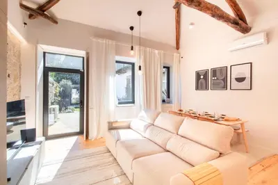 a living room with a white couch and a table at Olive Tree House by LovelyStay in Porto