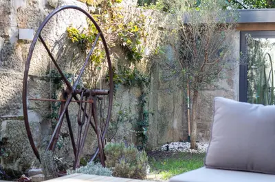 a metal sculpture next to a stone wall at Olive Tree House by LovelyStay in Porto
