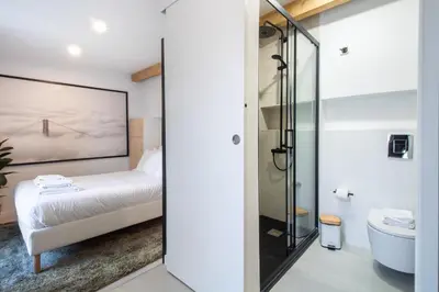 a bedroom with a bed and a bathroom with a shower at Olive Tree House by LovelyStay in Porto