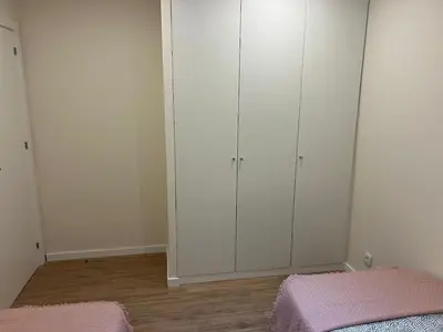 a bedroom with white cabinets and a pink bed at River Pace III in Porto