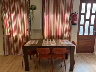a dining room table with orange chairs and curtains at River Pace III in Porto