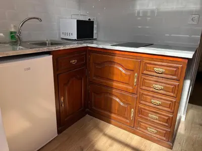 a kitchen with wooden cabinets and a sink and a microwave at River Pace III in Porto
