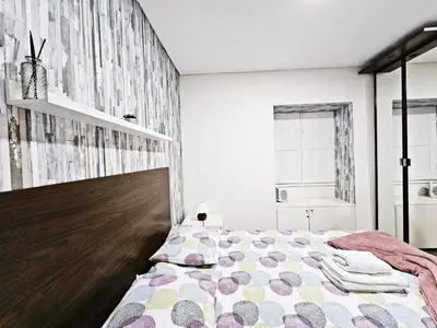 a bedroom with a bed with a wooden headboard at Ninho Studio in Vila Nova de Gaia