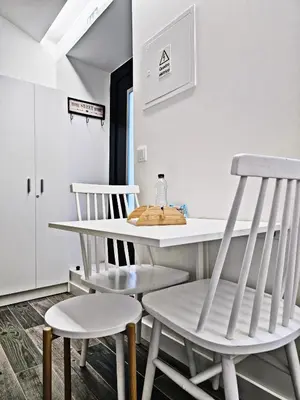 two white chairs and a table in a room at Ninho Studio in Vila Nova de Gaia