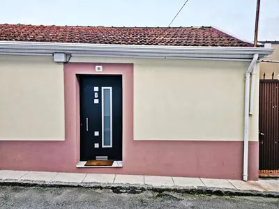 a pink and white house with a black door at Ninho Studio in Vila Nova de Gaia