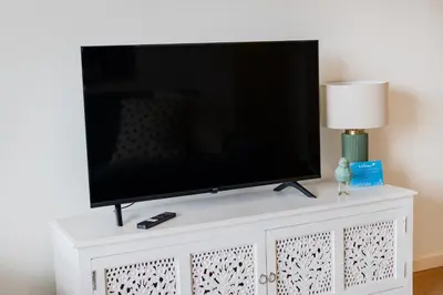 a living room with a blue couch and a kitchen at Antas Green Executive in Porto