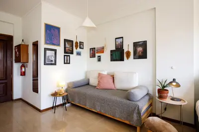 a bedroom with a bed with many pictures on the wall at Casa Guilhermina, Sunny Studio with Balcony in Porto