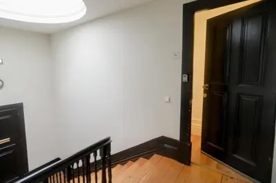 a hallway with a black door and a staircase at Cedofeita Downtown Nightlife by PCH in Porto
