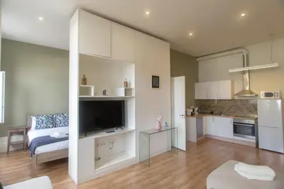 a living room with a television and a kitchen at Cedofeita Downtown Nightlife by PCH in Porto