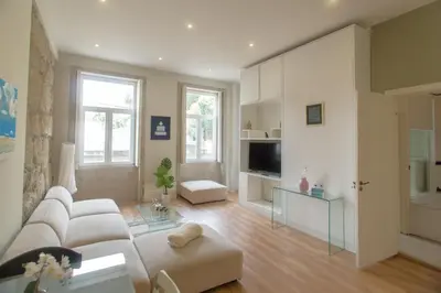 a living room with a white couch and a television at Cedofeita Downtown Nightlife by PCH in Porto